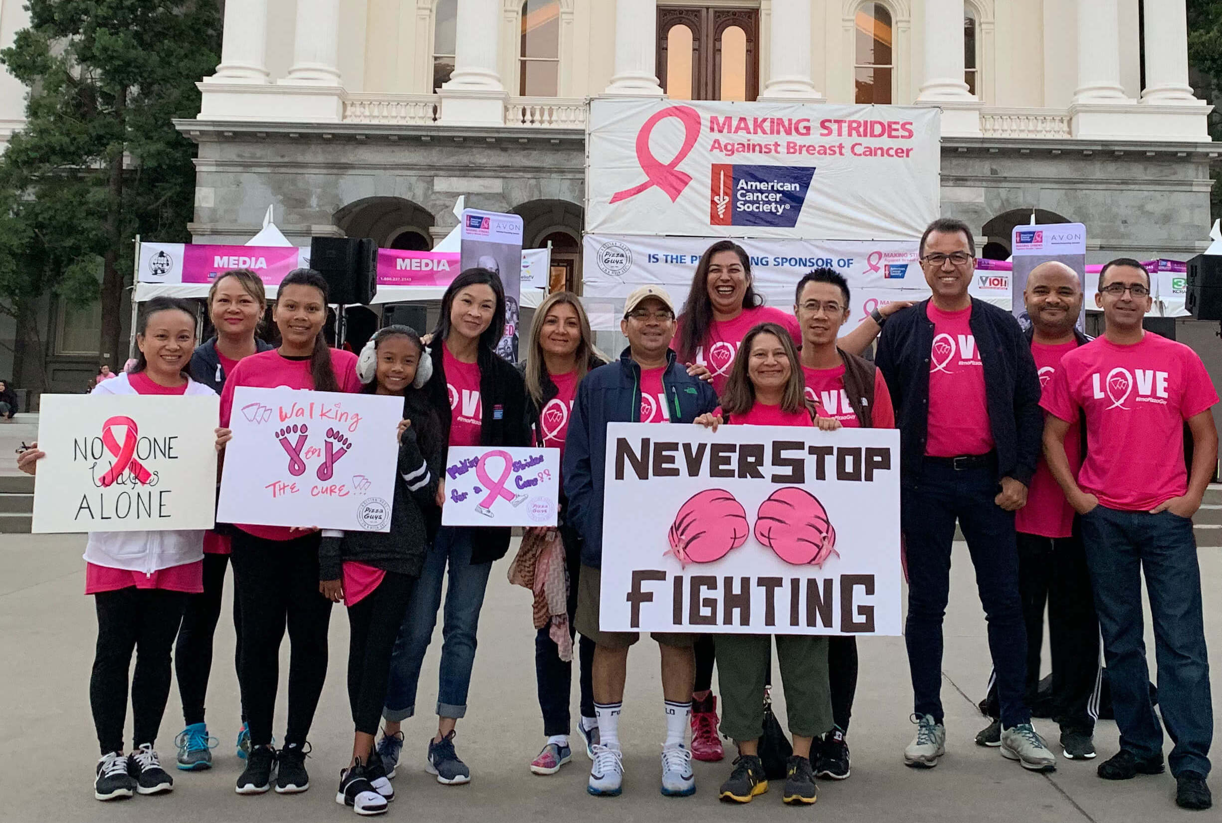 People standing in front of California Capital building for breast cancer awareness event.