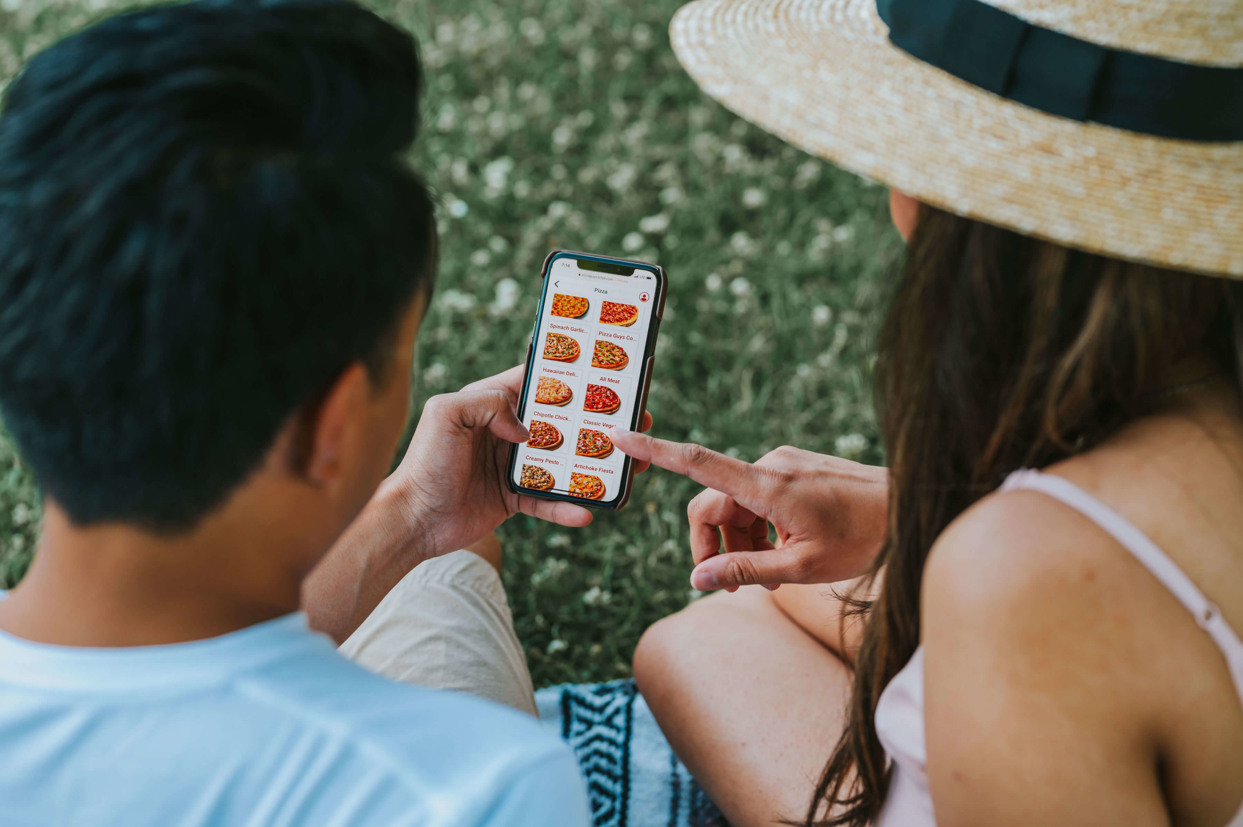 People looking at phone in order to select specialty pizza for lunch.